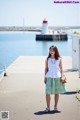 A woman standing on a pier near a body of water.