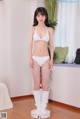 A woman in a white bikini standing on a scale.