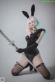 A woman in a bunny costume holding a sword.