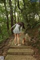 A woman in a gray dress is walking up some steps.