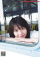 A young woman looking out of a train window.