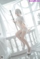 A woman in a white lingerie holding a sword.