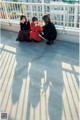 A group of women sitting on top of a roof.