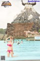 A woman in a pink bikini standing in a pool.
